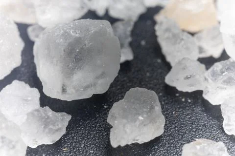 Close-up of salt crystals on a dark surface. Stock Photos
