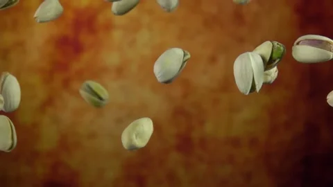 Close-up of salted Pistachios bouncing and rotating on a yellow ochre background Stock Footage 164733383