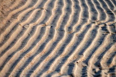 Close up of sand pattern on beach in summer with shallow depth of field Stock Photos