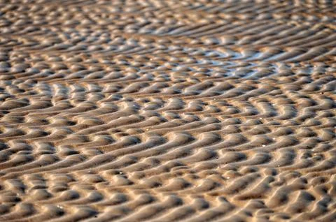 Close up of sand pattern on beach in summer with shallow depth of field Stock Photos