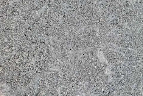 Close up to sand patterns and small sand pellets created by crab on beach. .. Stock Photos