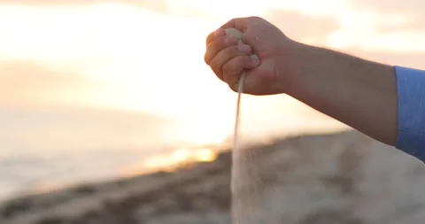 Close up of sand pouring from the hand on the beach on a sunny summer day. Sea Stock Footage 146287792