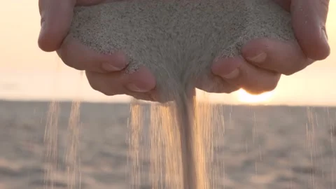 Close up of sand pouring from the hands on the beach Stock Footage 218457287