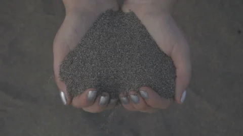Close up of sand through your fingers. Female hand taking up the sand Stock Footage 89783404