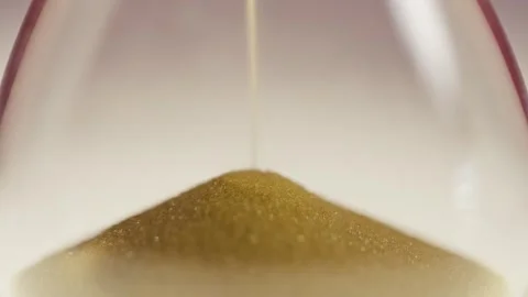 Close up of sand timer clock with sand flowing from through hourglass. Stock Footage 311091278
