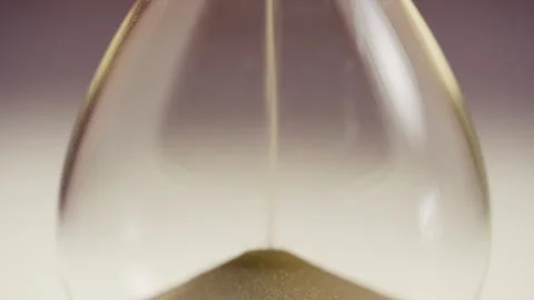 Close up of sand timer clock with sand flowing from through hourglass. Stock Footage 311091292