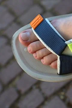 Close-Up of a Sandaled Foot on a Cobblestone Path in Casual Summer Fashion Stock Photos