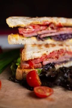 Close-up sandwich of two bread toasts with stuffing and vegetables on a woode Stock Photos