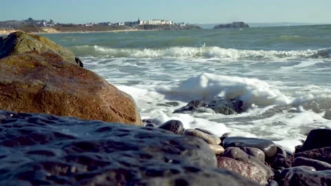 Close up of sandy beach with ocean waves coming inland. south wales tenby uk Stock Footage 152097176
