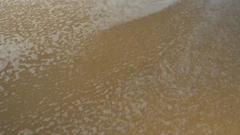 Close-up of a sandy beach with a wave crashing on it, in Vietnam Stock Footage 232502397
