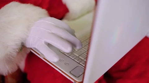 Close-up of Santa Claus' hands using a laptop computer. Sitting in a chair on Stock-Footage 218966200