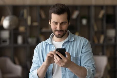 Close up satisfied man using phone, looking at screen Stock Photos