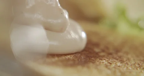 Close-up of the sauce on the bun for added cooking burger. 4K Slow Motion Stock Footage 117334153
