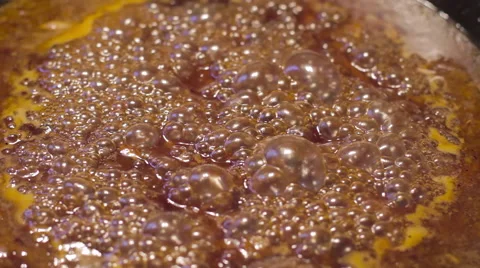 Close up of sauce caramelizing and bubbling in cast iron skillet Stock-Footage 60723406