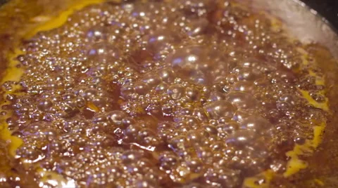 Close up of sauce caramelizing and bubbling in cast iron skillet in slow motion 스톡 동영상 60724011