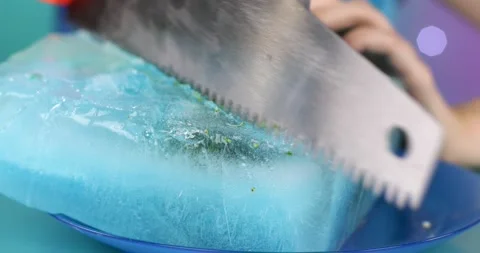Close-up of a saw cuts broccoli in a piece of ice Stock Footage 166554612