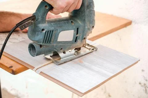 Close-up sawing jigsaw in the board, the process of cutting the board Stock Photos