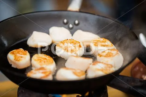 Close up of scallops frying in cast iron pan Stock Photos