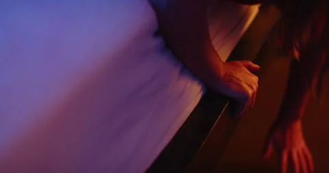 Close up of scared woman looking underneath her bed Stock Footage 253395805