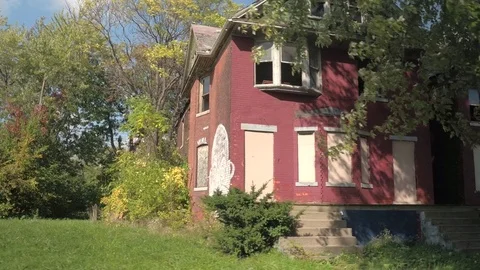 CLOSE UP: Scary graffiti on abandoned decaying house surrounded by lush foliage Stock Footage 76718190