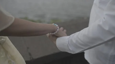 A close scene of couple holding each others hands near lake Video stock 325416461