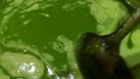 Close-up scene of green liquid mixture being stirred Video stock 305850898