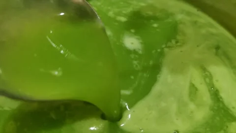 Close-up scene of green liquid mixture being stirred Stock Footage 305851056