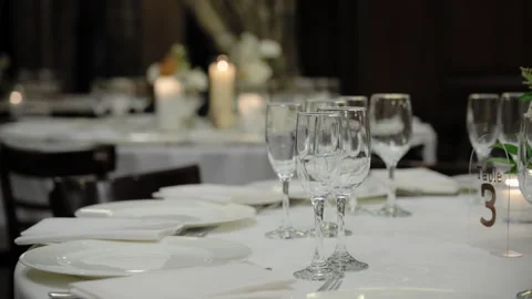 Close-up scene of served table with glasses, plates and cutlery at the party at Stock Footage 304298363
