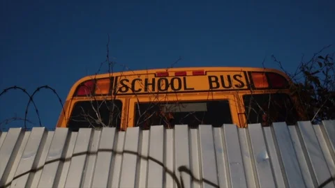 Close up of school bus behind mental fence with barbed wire Stock-Footage 98666607