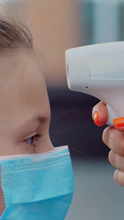 Close-up. school nurse, using digital digital infrared thermometer, screens body Stock Footage 315759970