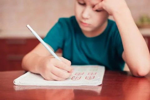 Close up of schoolboy learn math at homework, small DoF, focus on hand Stock Photos