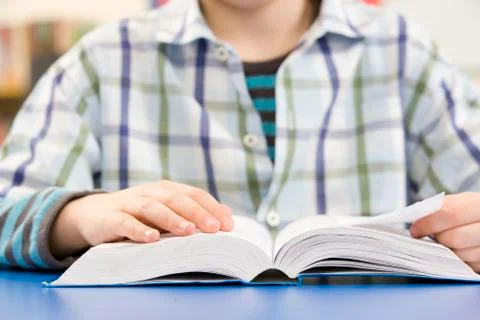 Close Up Of Schoolboy Studying Textbook In Classroom Stock Photos