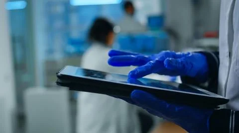 Close up of scientist examining datas from tablet Stock Photos