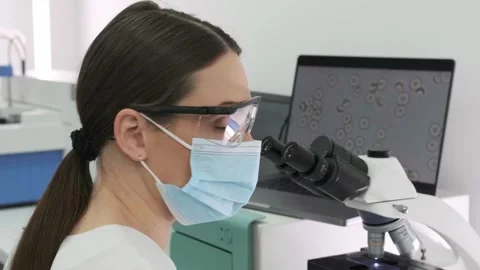 Close-up of a scientist examining samples under a microscope Stock Footage 269289814