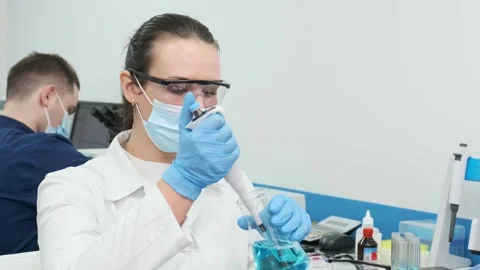 Close-up of a scientist examining samples under a microscope Видео 269300634