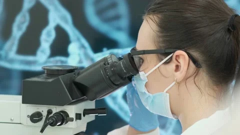 Close-up of a scientist examining samples under a microscope Видео 269304702