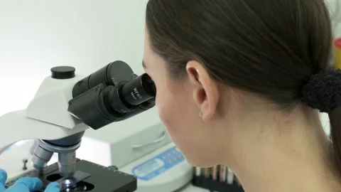 Close-up of a scientist examining samples under a microscope Видео 269313438
