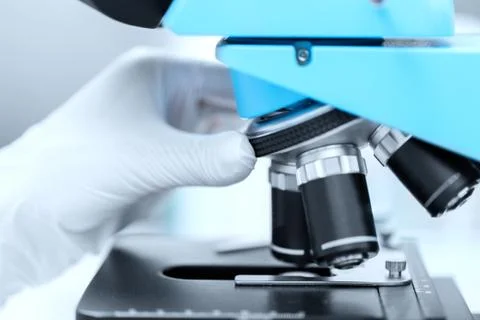 Close up of scientist hand setting microscope Stock Photos