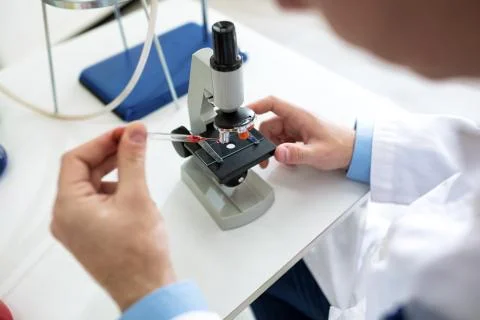 Close up scientist hands with microscope Stock Photos