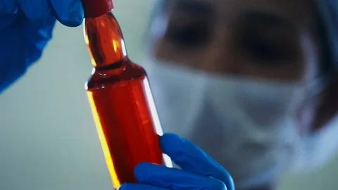 Close up of a scientist inspecting a bottle of purified macauba palm oil. Stock Footage 101714154