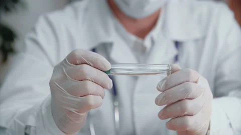 Close-up of a scientist in a laboratory holding a clear liquid in a test tube. Stock Footage 154162864