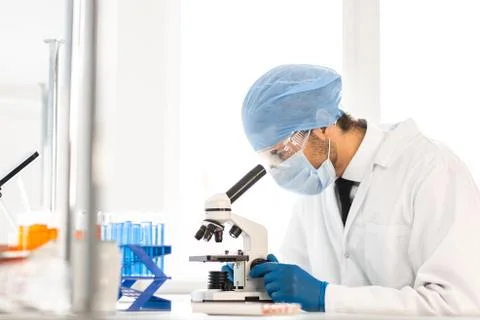 Close up. scientist looking into the eyepiece of a microscope. Stock Photos