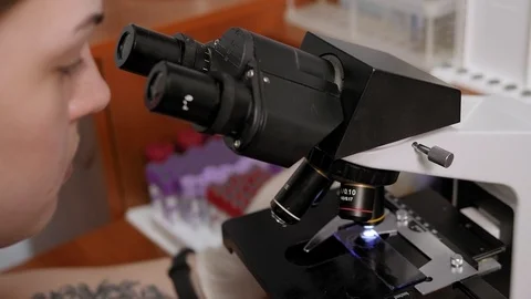 Close-up of a scientist looking into a microscope in a laboratory. Stock Footage 127965050