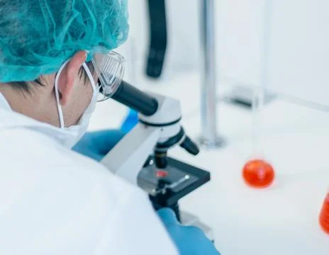 Close up. scientist looking through a microscope. Stock Photos