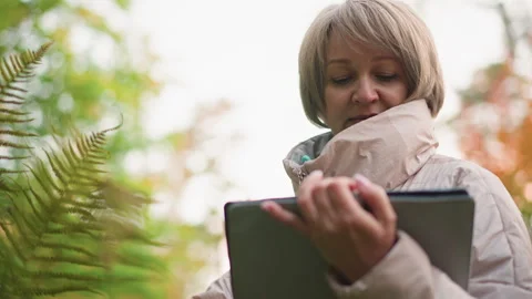 Close up of scientist recording field notes while observing plant in autumn Stock Footage 316693402