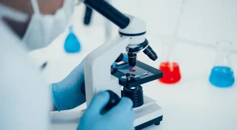 Close up. scientist setting up his microscope to work. Stock Photos