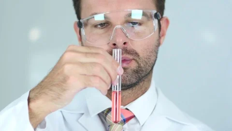Close Up of Scientist Studying Red Chemical Solution in Test Tube Stock Footage 81165481