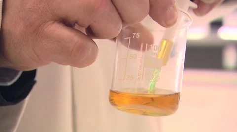 Close Up of Scientist Taking Sample of Liquid From Measuring Beaker With Syringe Stock Footage 40619909