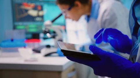 Close up of scientist writing on tablet Stock Photos