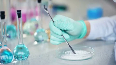 Close-up of scientist's hand preparing powder on glass dish for some research in 動画素材 85329147